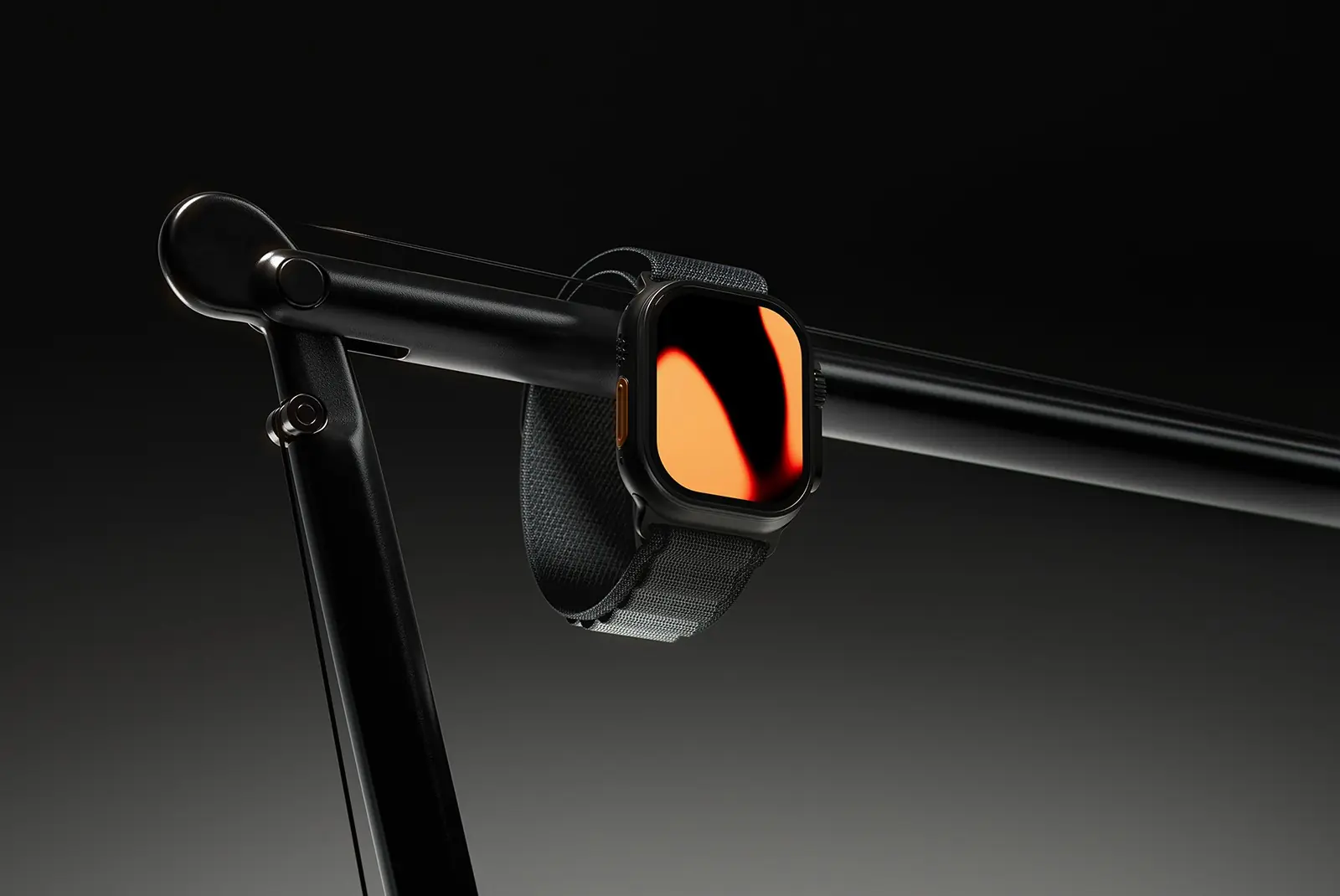 Studio shot of a black smartwatch with an orange display