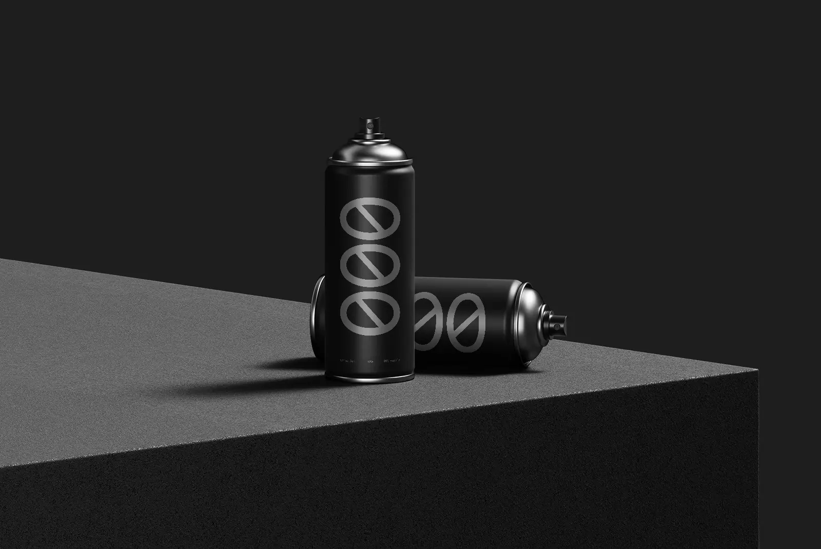 Two black spray cans resting on a grey surface